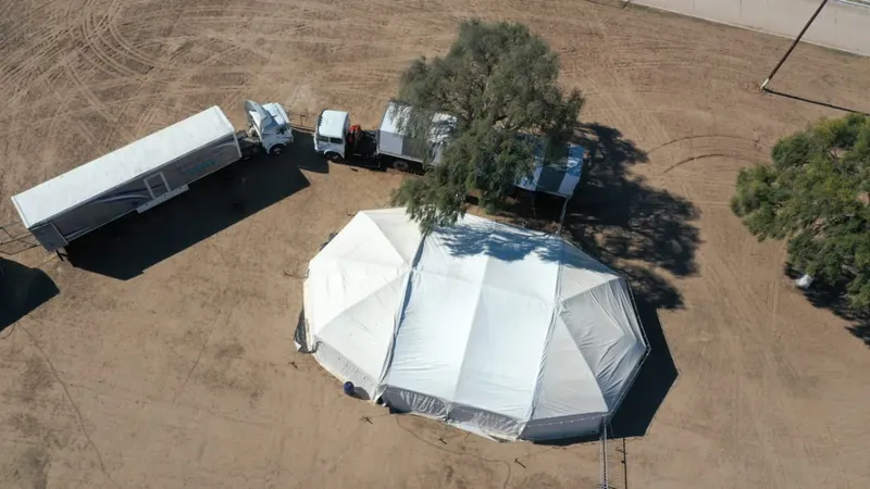 Vista aérea de los camiones y la carpa en el predio.